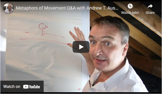 A man gestures towards a flip chart with a simple red drawing of a person and a line during the MoM Q&A video session in March 2020. | Andrew T. Austin | Metaphors of Movement